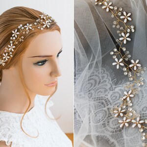 May include: Gold bridal hair vine with white flowers and rhinestones. The vine is shown on a white lace background and on a model's head.