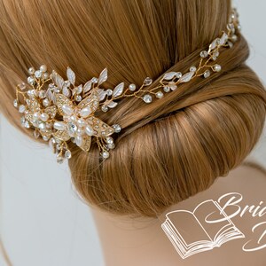 May include: Gold bridal hair comb with pearl and crystal embellishments. The comb is adorned with delicate floral designs and is perfect for adding a touch of sparkle to any bridal hairstyle.