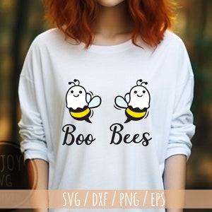 May include: White long-sleeved shirt featuring a graphic of two cartoon bees with ghost faces. The text "Boo Bees" is printed below the bees.