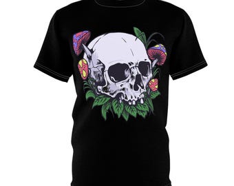 Op de afbeelding: Zwart t-shirt met een witte schedel, aangevuld met paarse, rode en gele paddenstoelen en groene bladeren. De afbeelding is gecentreerd op de voorkant van het shirt.