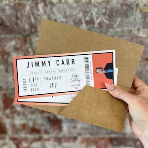 K&ouml;nnte beinhalten: Ein brauner Umschlag mit einem Ticket f&uuml;r "JIMMY CARR" in der "UTILITY ARENA, NEWCASTLE". Auf dem Ticket steht "07. DEZ. 2024" und "SHOW STARTS: 20 Uhr". Das Ticket hat einen pfirsichfarbenen Rand und ein Bild eines Mannes.
