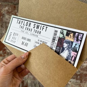 K&ouml;nnte beinhalten: Ein Konzertticket f&uuml;r Taylor Swifts 'The Eras Tour' in The O2, London, vom 19. August 2024, ist teilweise in einem braunen Umschlag zu sehen. Das Ticket zeigt eine Collage von Bildern und den Text 'Doors Open: 16:00'.