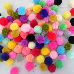 Puede incluir: Una gran colección de pompones coloridos en varios tonos de rosa, azul, verde, amarillo, rojo, morado y negro. Los pompones están hechos de hilo y son suaves y esponjosos.
