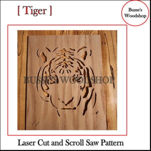 May include: A laser cut wooden pattern of a tiger's face. The pattern is on a light brown piece of wood with a darker brown grain. The pattern is ready to be used for scroll saw or laser cutting projects.