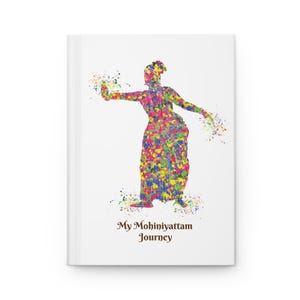 May include: A white notebook featuring a vibrant watercolour illustration of a dancer in traditional dress. The dancer is rendered in yellow, blue, red, and green hues. The text "My Mohiniyattam Journey" is printed in brown at the bottom of the notebook.