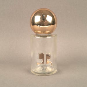 May include: A clear glass bottle with a gold-colored top and the number "35" printed on the front.