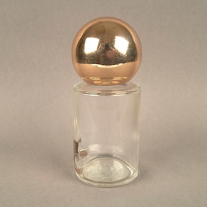 May include: A clear glass bottle with a gold-colored spherical stopper.