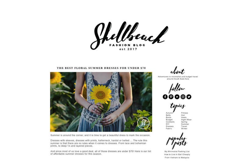 May include: A blog post titled "Shellbeach Fashion Blog" with the text "The Best Floral Summer Dresses for Under $70." The image features a person holding a sunflower in a field of sunflowers, wearing a blue dress.