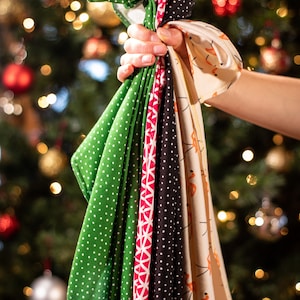 May include: A collection of six fabric squares with different patterns. The squares are green with white polka dots, red and white geometric, black with white polka dots, beige with orange flamingo print, and two more with different patterns.