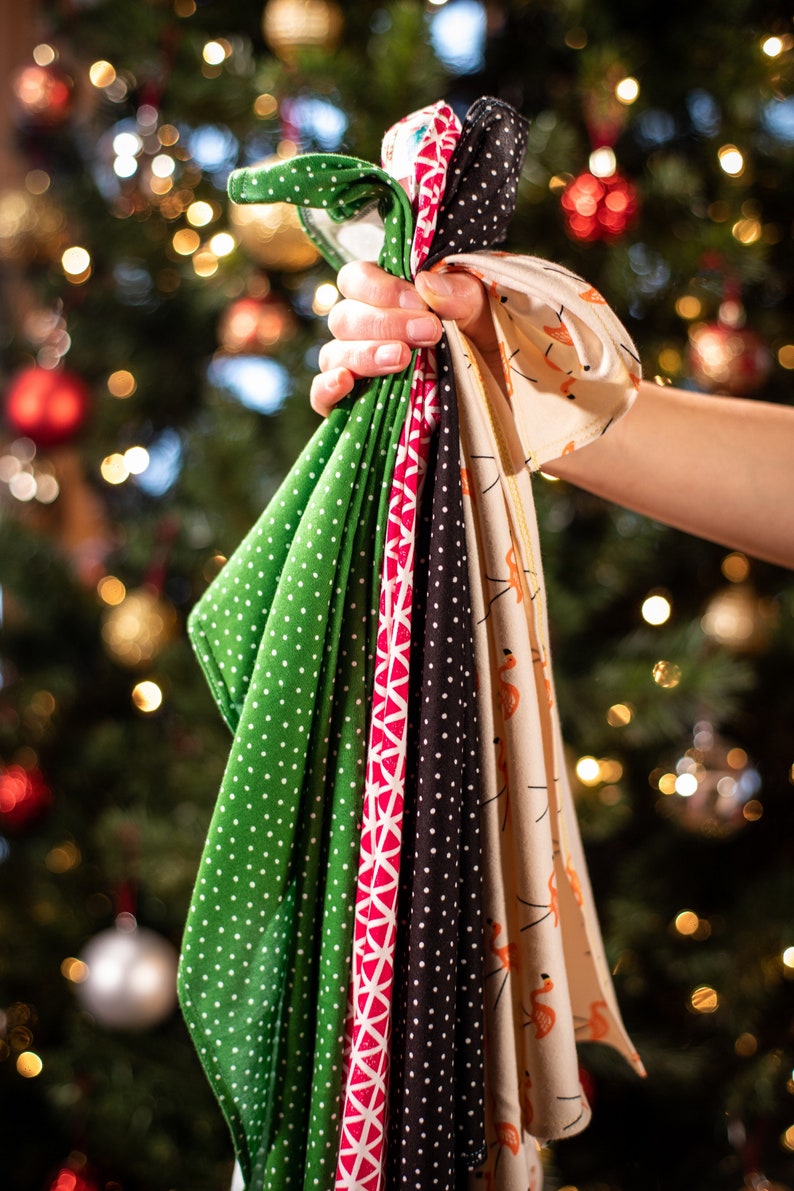 May include: A collection of six fabric squares with different patterns. The squares are green with white polka dots, red and white geometric, black with white polka dots, beige with orange flamingo print, and two more with different patterns.