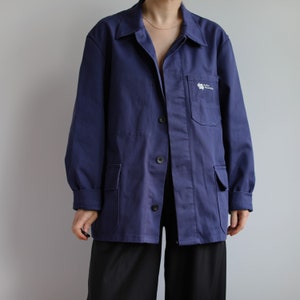 May include: A dark blue work jacket with a white logo that says "Taller Mecanico" on the left chest pocket.