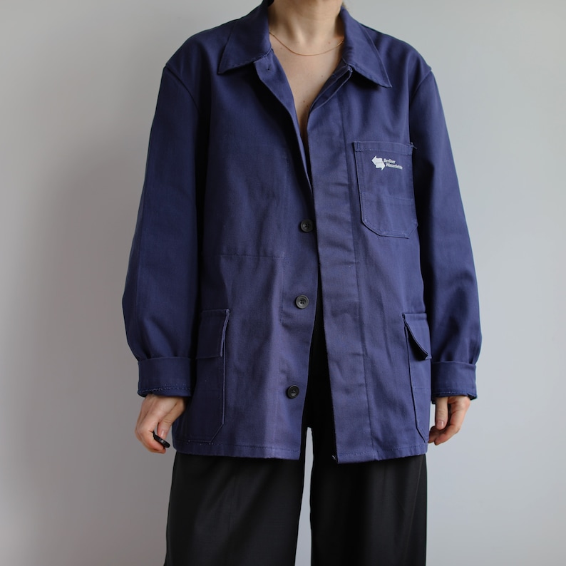 May include: A dark blue work jacket with a white logo that says "Taller Mecanico" on the left chest pocket.