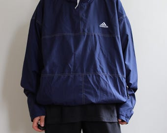 Vintage navy blue Adidas windbreaker jacket with hood. Originally men’s size L. 90’s era.