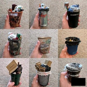 May include: Nine different metal mesh desk organizers with various items inside, including trash bags, paper, and other office supplies. Some of the organizers have labels that say "Garbage" and "Supply Jail".