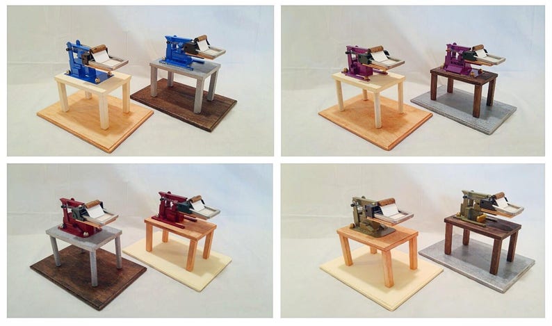 May include: Six miniature printing presses on wooden bases. The presses are painted in various colors, including blue, red, purple, and green. The bases are painted in various colors, including brown, white, and gray.