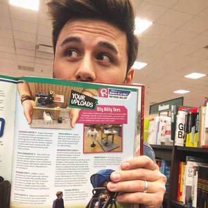 May include: A man is holding open a magazine with a spread about unusual facts. The magazine features a photo of a tiny T-shirt printed on a tiny screen, a photo of a spinning top, and a photo of a robot relay race. The magazine is titled "Believe It or Not! Beyond Belief".