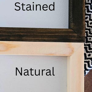 May include: Close-up of two wooden framed signs. One sign has a dark stained frame with the word "Stained" in black text. The other sign has a natural wood frame with the word "Natural" in black text.