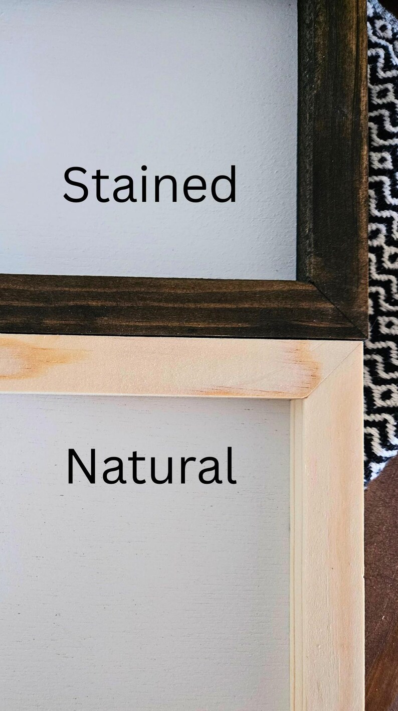 May include: Close-up of two wooden framed signs. One sign has a dark stained frame with the word "Stained" in black text. The other sign has a natural wood frame with the word "Natural" in black text.