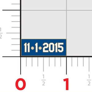 May include: A blue and white enamel pin with the text "11-1-2015" and two baseballs.