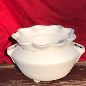 May include: White ceramic planter with a scalloped rim and three legs. The planter is made of unglazed ceramic and is ready to be painted.