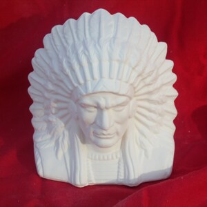 May include: White ceramic bust of a Native American man wearing a headdress. The bust is a blank canvas for painting.