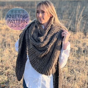 May include: A chunky, dark brown knit shawl featuring a textured, ribbed pattern. The garment is draped over a white collared shirt. A circular graphic overlay in the upper left corner contains the text KNITTING PATTERN in dark blue letters.