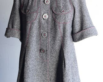 May include: A gray hooded jacket with pink stitching and multiple buttons. The jacket has a slightly flared shape and short sleeves.