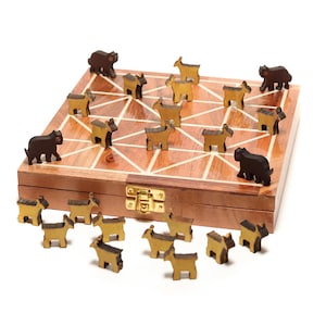 Puede incluir: Un juego de mesa de madera con un diseño geométrico, con piezas de juego con forma de animales marrones y doradas. El juego está alojado en una caja de madera con un cierre dorado. Las piezas están dispuestas sobre y alrededor del tablero.