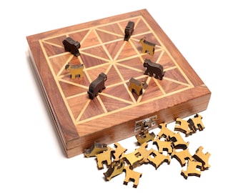 Könnte beinhalten: Ein quadratisches Brettspiel aus Holz mit geometrischem Gittermuster und einem Metallverschluss an der Seite. Mehrere dunkelbraune und hellbeige, tierförmige Holzspielfiguren sind auf dem Brett platziert, weitere liegen in einem Haufen davor.