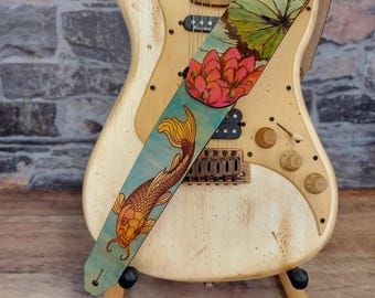 Correa de guitarra de cuero premium con lirios y koi. Pintada a mano con vibrantes colores sobre cuero flor turquesa apagado. Talla ajustable.