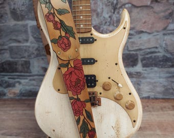 Correa de guitarra de cuero hecha a mano con peonías de árbol rojo: flores de peonía japonesas teñidas a mano en rojo y verde sobre cuero bronceado ligeramente desgastado.