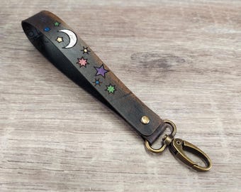 Correa de muñeca de cuero premium con luna y estrellas de colores en negro antiguo: cordón de muñeca celestial para llavero, billetera, bolso de mano o dije para bolso.