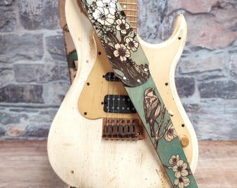 Correa de guitarra de cuero Sakura Songbird: Correa para instrumento hecha a mano en cuero grueso de primera calidad en tonos turquesa apagado, natural y plateado.