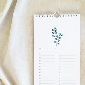 Pu&ograve; includere: Un calendario bianco con un design semplice che presenta un piccolo ramo verde con foglie. Il calendario &egrave; per giugno e ha i giorni numerati da 1 a 30.