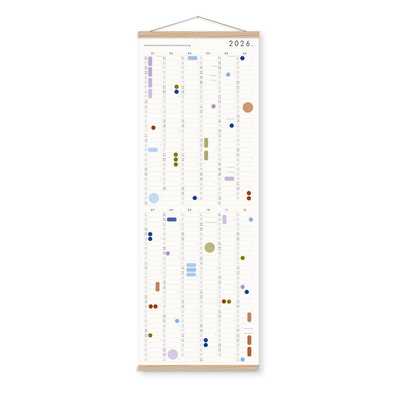 K&ouml;nnte beinhalten: Ein vertikaler Wandkalender f&uuml;r 2026 mit einem hellen Holzrahmen oben und unten sowie einer Aufh&auml;ngeschnur. Das wei&szlig;e Papier zeigt ein Raster aus Monaten und Tagen, das mit verschiedenen farbigen Kreisen und ovalen Symbolen in Blau, Gr&uuml;n und Braun markiert ist.