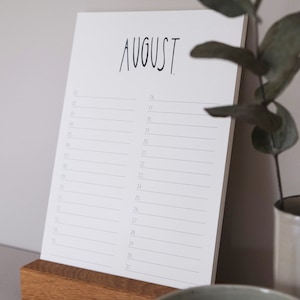 May include: A white calendar with the word "AUGUST" printed in black at the top. The calendar has a simple design with numbered days listed down the left side and blank lines for writing appointments.