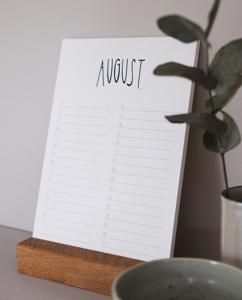 May include: A white calendar with the word "AUGUST" printed in black at the top. The calendar has a simple design with numbered days listed down the left side and blank lines for writing appointments.