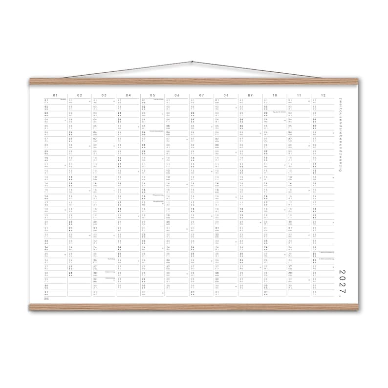 Peut inclure: Un calendrier mural 2027 pr&eacute;sentant une mise en page en grille avec douze colonnes pour chaque mois, imprim&eacute; en noir sur un fond blanc. Le calendrier est maintenu par des baguettes en bois clair en haut et en bas, avec une fine ficelle.