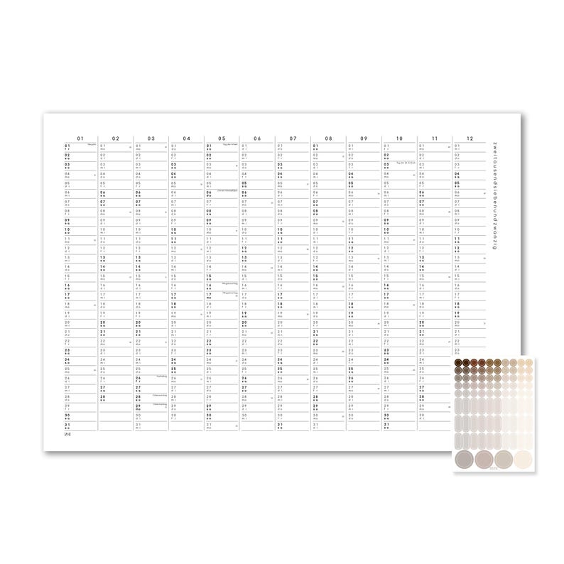 Peut inclure: Un calendrier mural blanc pr&eacute;sentant une grille verticale pour douze mois, avec le texte zweitausendiebenundzwanzig imprim&eacute; sur le c&ocirc;t&eacute; droit. Une feuille s&eacute;par&eacute;e d'autocollants circulaires dans un d&eacute;grad&eacute; de tons marron et beige est incluse.