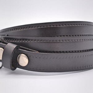 May include: A brown leather belt with a stitched design and silver buckle.