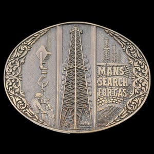 May include: Oval-shaped, bronze-toned belt buckle featuring an oil derrick, a worker, and the text "MAN'S SEARCH FOR GAS." The buckle has an ornate border and depicts an industrial scene.