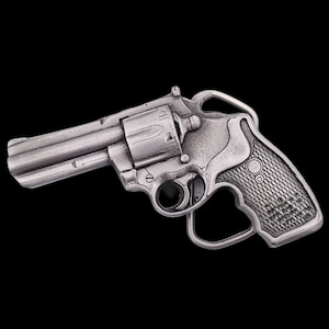 May include: A silver-toned metal belt buckle shaped like a revolver.