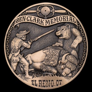 May include: A bronze-colored Ben Clark Memorial coin. The coin depicts a frontiersman aiming a rifle at a bear attacking a bison. The text "BEN CLARK MEMORIAL" and "EL RENO. OK" are inscribed on the coin.
