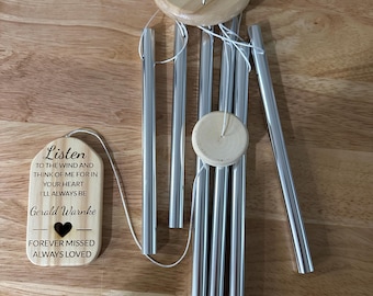 May include: A wooden wind chime with a silver metal chime tube. The wooden plaque reads "Listen to the wind and think of me for in your heart I'll always be Gerald Warnke Forever missed Always loved".