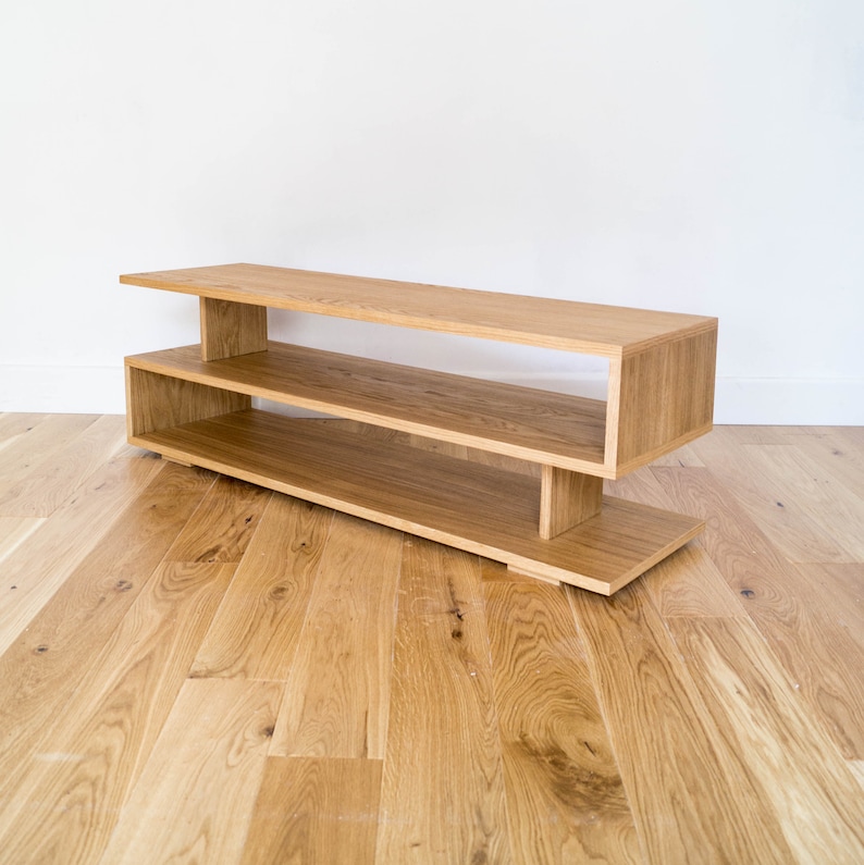 May include: A light wood entertainment center with two shelves. The shelves are open and the unit has a modern design.