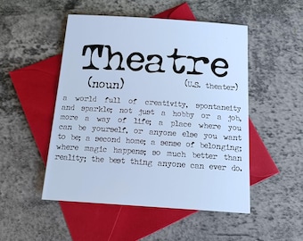 May include: A white card with the word "Theatre" in bold black letters, with a definition below. The card is on top of a red envelope, with a gray surface in the background.