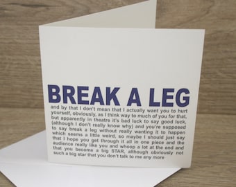 May include: A white card with the text "BREAK A LEG" in blue letters. The card has a humorous message about the phrase "break a leg" and its use in the theater.