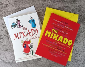 May include: Two greeting cards with envelopes. The white card features illustrations of characters and the text The MIKADO or The Town of Titipu. The red card features yellow text reading THE MIKADO and THE TOWN OF TITIPU with various smaller words.