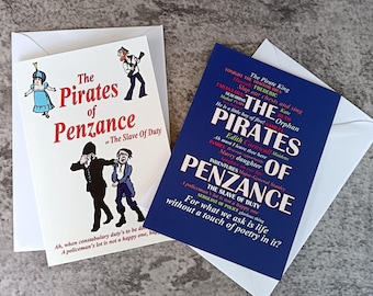 May include: Two greeting cards featuring The Pirates of Penzance. One white card shows cartoon characters and the text The Pirates of Penzance or The Slave Of Duty. The second blue card features a word cloud of lyrics and quotes from the opera.