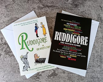 May include: Two greeting cards featuring Ruddigore themes. One white card shows a man and woman, a ghost, and a tombstone with text. The other black card features the title Ruddigore, The Witch's Curse, and a list of character names in various colors.